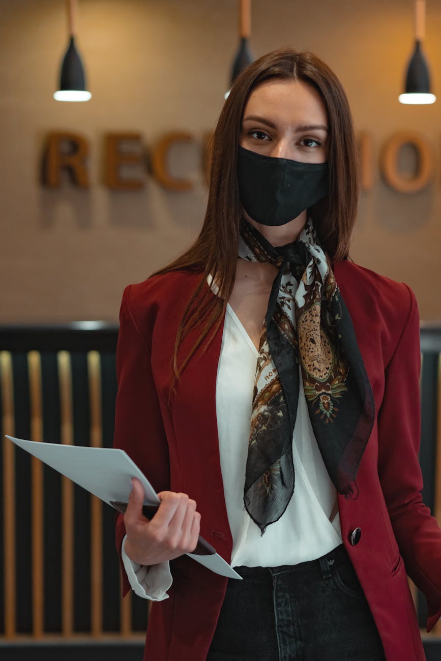 Professional woman at reception desk greeting visitor in modern office lobby