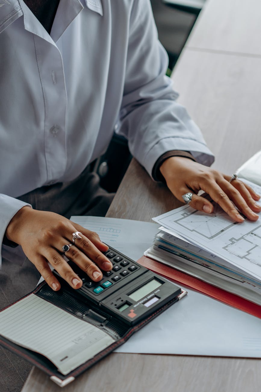 Accountant working with financial reports and calculator at organized desk