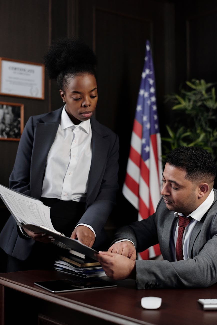 Paralegal at desk with legal nameplate filing documents in law office